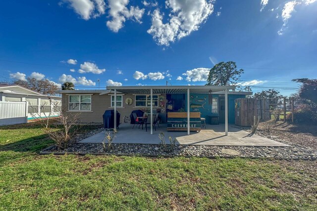 back of property with a patio and a lawn