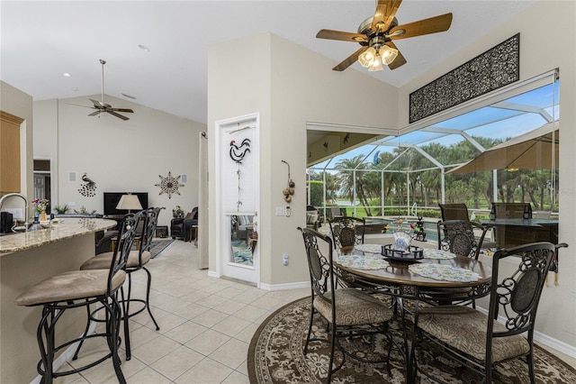 tiled dining space with sink, high vaulted ceiling, and ceiling fan