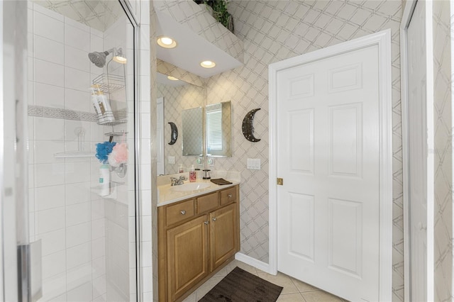 bathroom with a shower with door, vanity, and tile patterned floors