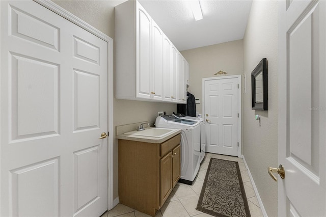 washroom with sink, light tile patterned flooring, cabinets, and separate washer and dryer