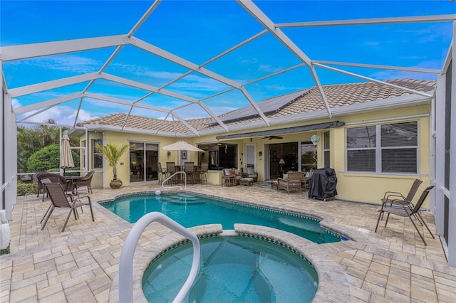 view of pool with a lanai, an in ground hot tub, a patio area, and ceiling fan