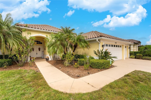 mediterranean / spanish home featuring a front lawn and a garage