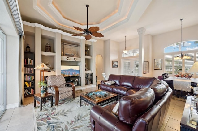 living room featuring built in shelves, light tile patterned flooring, ceiling fan with notable chandelier, and french doors