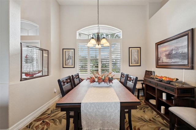 dining area featuring a high ceiling and a notable chandelier