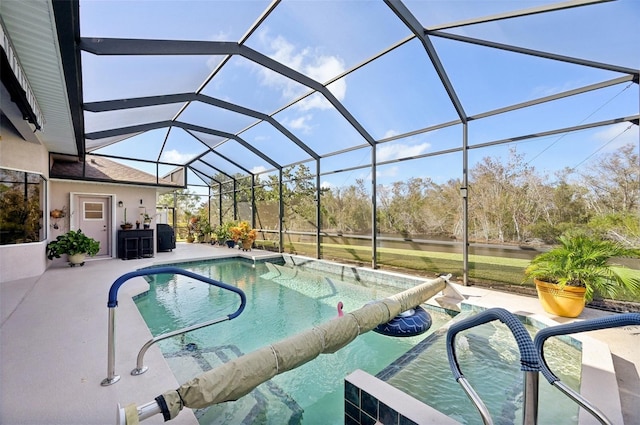 view of pool featuring glass enclosure and a patio area