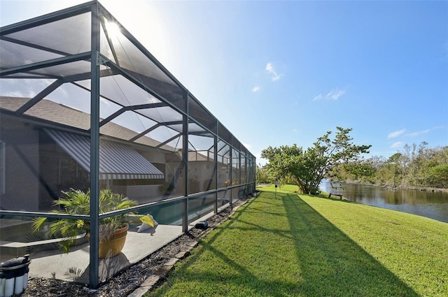 view of yard with a lanai and a water view