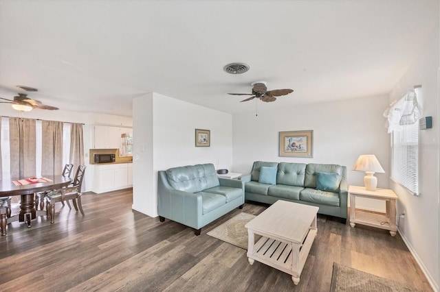 living room with dark hardwood / wood-style floors and ceiling fan