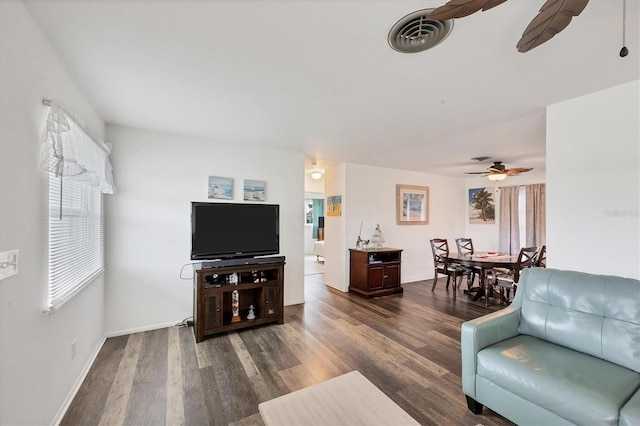 living room with dark wood-type flooring and ceiling fan