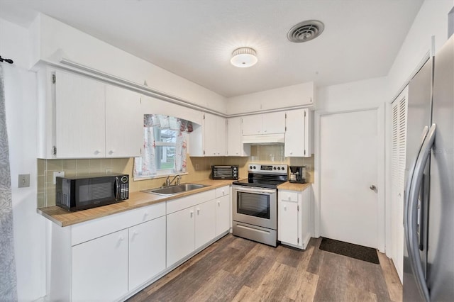 kitchen with tasteful backsplash, sink, white cabinetry, stainless steel appliances, and dark hardwood / wood-style floors