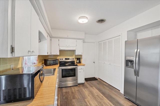 kitchen with backsplash, appliances with stainless steel finishes, dark hardwood / wood-style flooring, white cabinetry, and sink