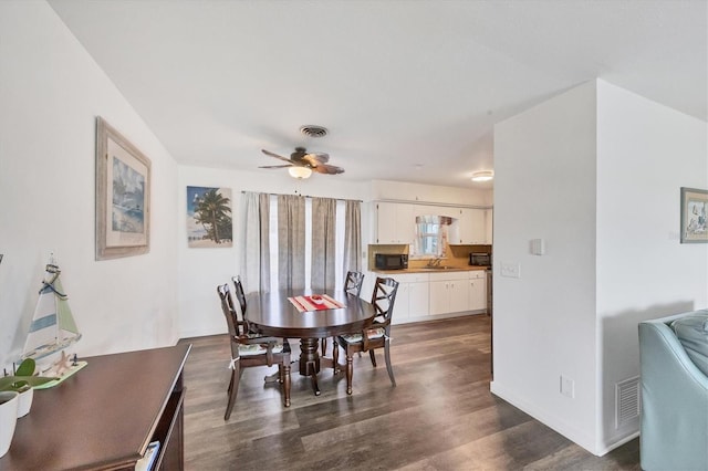 dining space with sink, dark hardwood / wood-style floors, and ceiling fan