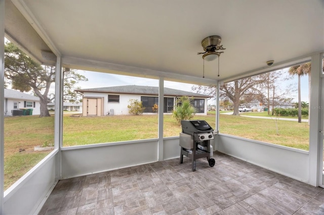 unfurnished sunroom featuring ceiling fan