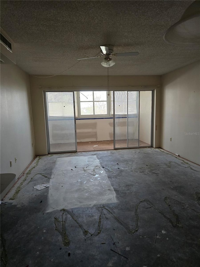 2300 Aaron St Unit 315, Port Charlotte, FL 33952 - unfurnished room featuring healthy amount of natural light, a textured ceiling, ceiling fan, and unfinished concrete floors
