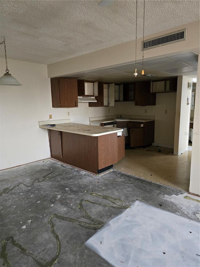 2300 Aaron St Unit 315, Port Charlotte, FL 33952 - kitchen featuring a peninsula, a textured ceiling, under cabinet range hood, and decorative light fixtures