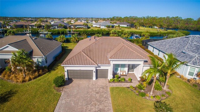 15048 Spanish Point Dr, Port Charlotte, FL 33981 - view of front of property with a garage, decorative driveway, a water view, a residential view, and stucco siding