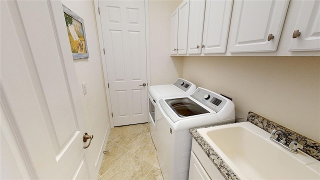 laundry room featuring cabinets, washing machine and dryer, sink, and light tile patterned floors