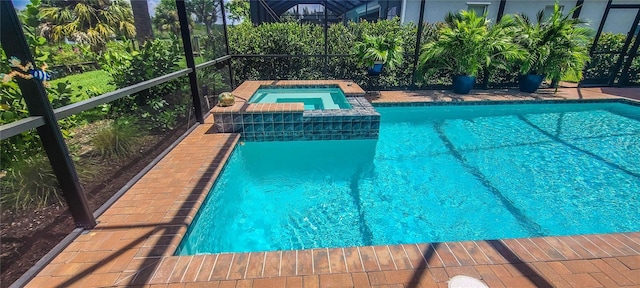 view of swimming pool featuring an in ground hot tub and a lanai