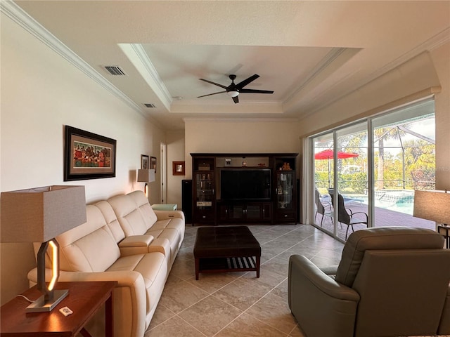 living room featuring crown molding, light tile patterned floors, ceiling fan, and a tray ceiling