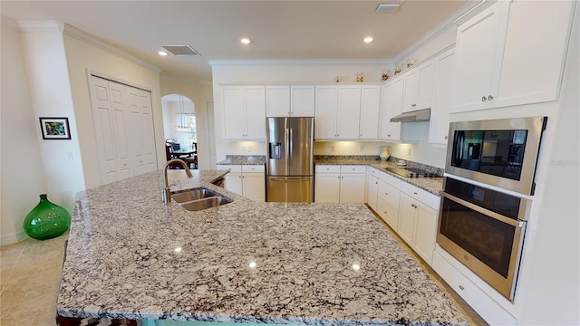 kitchen with a large island with sink, sink, white cabinets, and black appliances