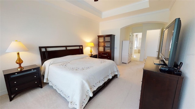 bedroom featuring crown molding, light colored carpet, and a tray ceiling