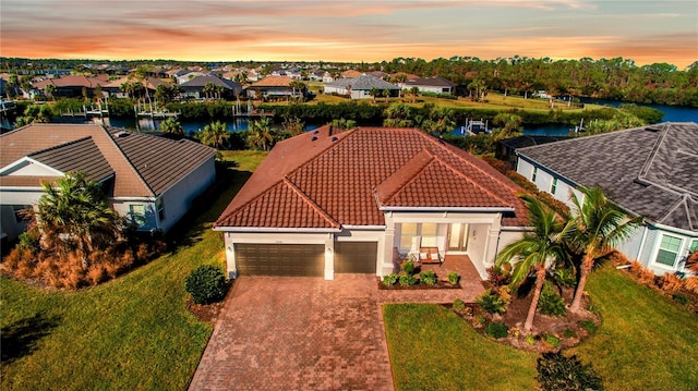 view of front of home featuring a water view, a garage, and a yard