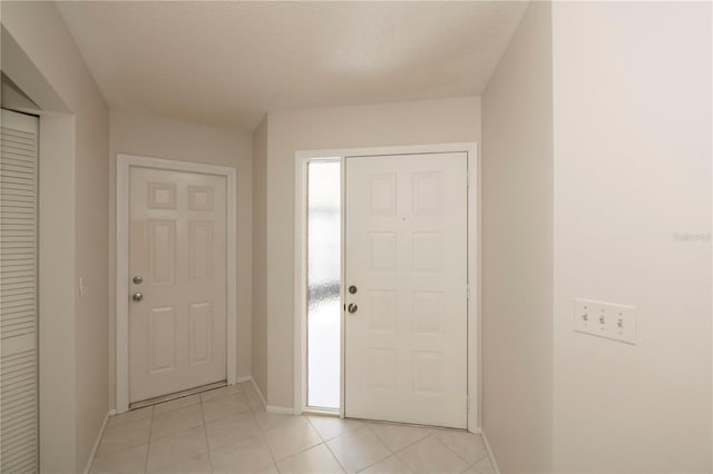 tiled foyer entrance featuring a textured ceiling