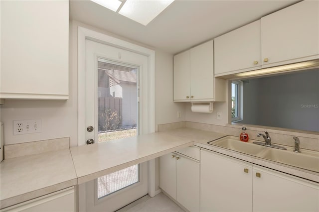 kitchen featuring white cabinetry and sink