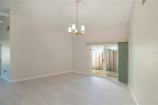 empty room featuring an inviting chandelier and light hardwood / wood-style flooring