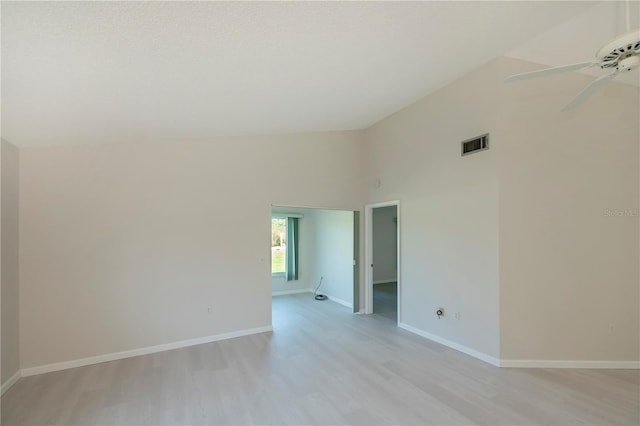 empty room featuring ceiling fan, high vaulted ceiling, and light hardwood / wood-style flooring