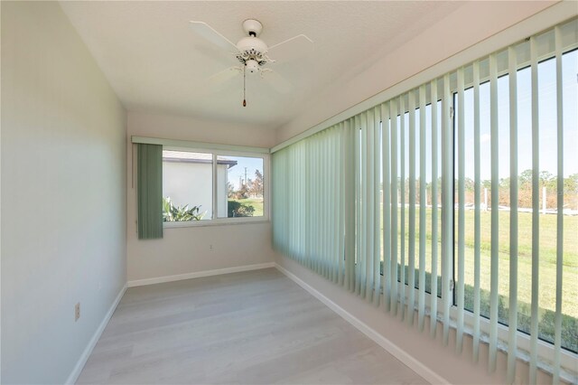 unfurnished sunroom with ceiling fan