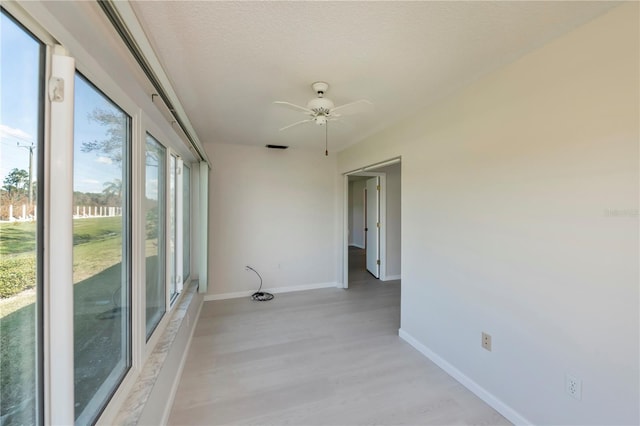 spare room with light hardwood / wood-style flooring, a textured ceiling, and ceiling fan