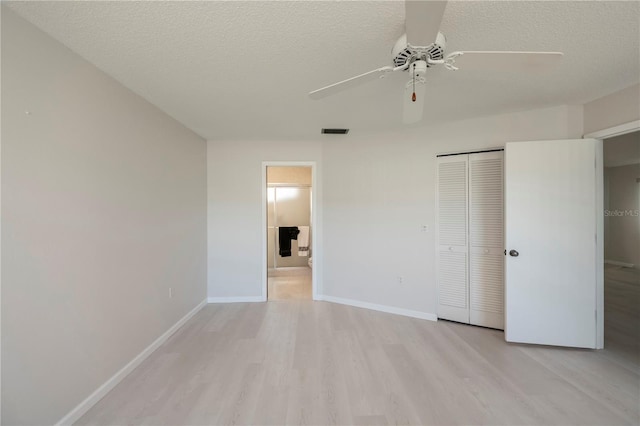 unfurnished bedroom with a textured ceiling, light wood-type flooring, a closet, and ceiling fan