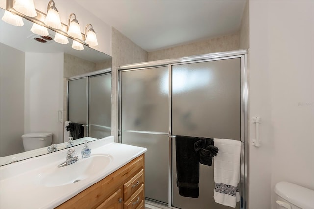 bathroom with toilet, walk in shower, and vanity