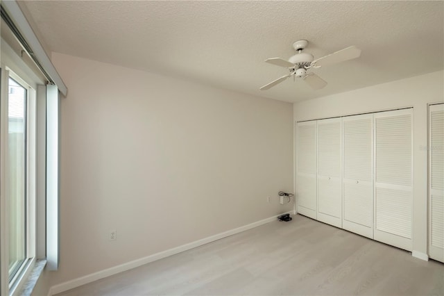 unfurnished bedroom featuring ceiling fan, a textured ceiling, and light hardwood / wood-style floors