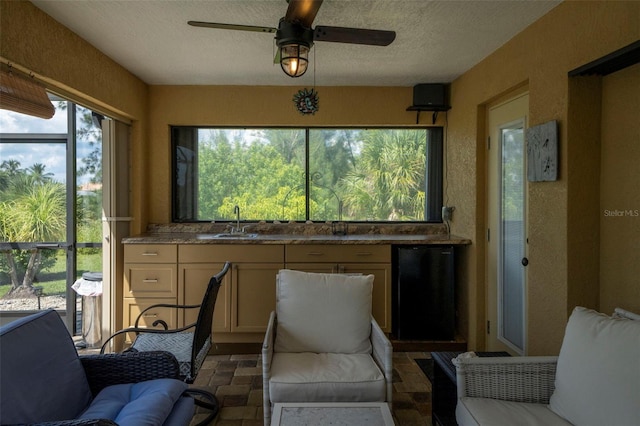 sunroom / solarium featuring ceiling fan and sink