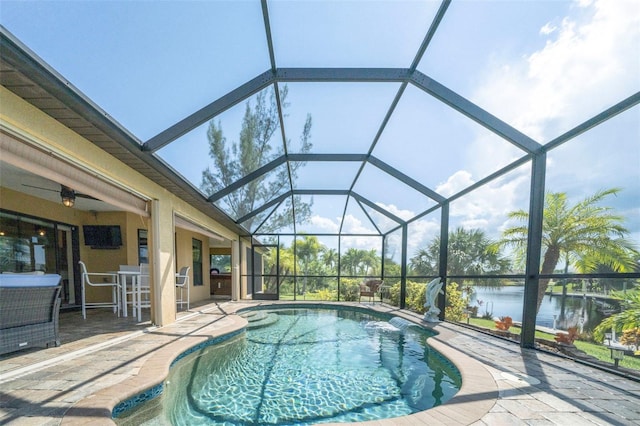 view of pool with glass enclosure, a water view, and a patio