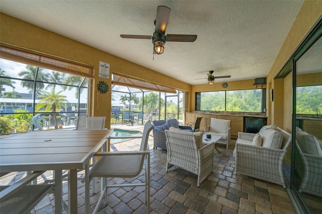 sunroom featuring ceiling fan and plenty of natural light