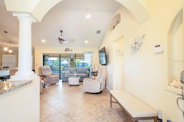 tiled living room with decorative columns, ceiling fan, and lofted ceiling