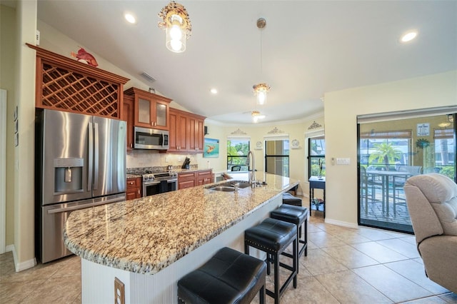 kitchen with sink, decorative backsplash, a wealth of natural light, decorative light fixtures, and stainless steel appliances