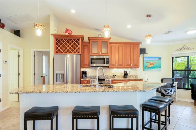 kitchen featuring backsplash, stainless steel appliances, pendant lighting, lofted ceiling, and an island with sink