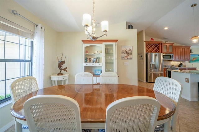 dining space with a chandelier and vaulted ceiling