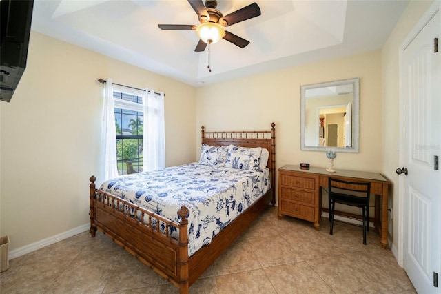 bedroom with light tile patterned floors, a raised ceiling, and ceiling fan