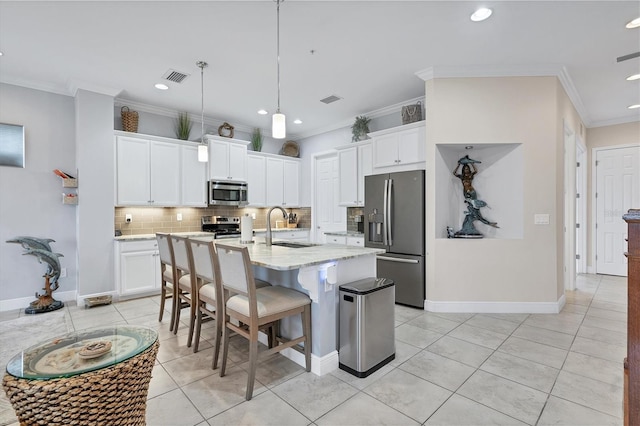 kitchen featuring a center island with sink, white cabinetry, ornamental molding, sink, and stainless steel appliances