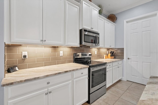 kitchen featuring light stone countertops, white cabinets, stainless steel appliances, and light tile patterned flooring