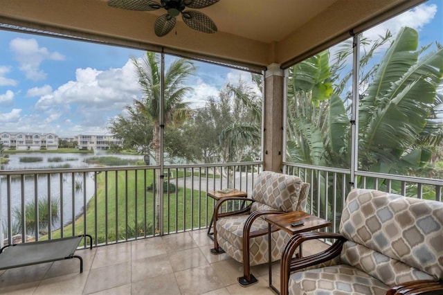 sunroom / solarium with a water view and ceiling fan