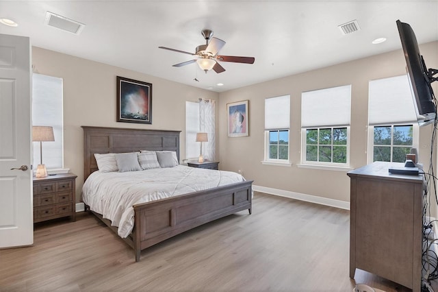 bedroom with light hardwood / wood-style flooring, multiple windows, and ceiling fan