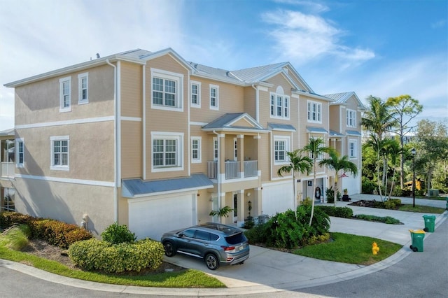 10311 Lands End Cir Unit 13, Placida, FL 33946 - view of property featuring concrete driveway, stucco siding, an attached garage, metal roof, and a standing seam roof