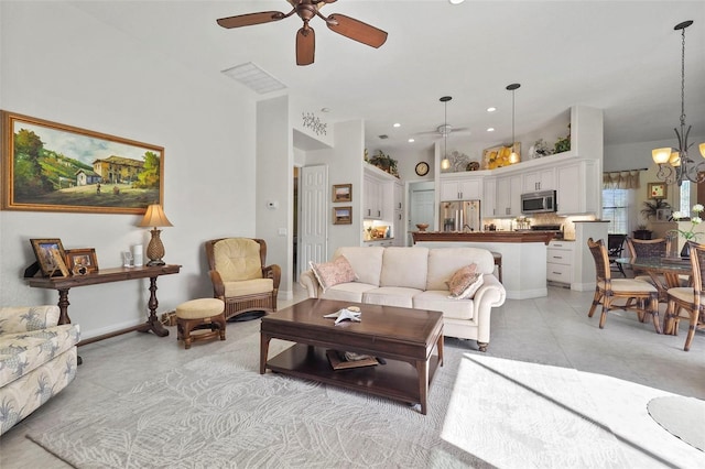 living room featuring ceiling fan with notable chandelier