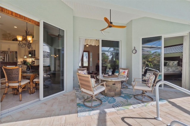 sunroom with vaulted ceiling with beams and ceiling fan with notable chandelier