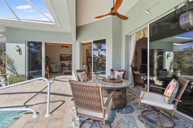 view of patio featuring a lanai, a fire pit, and ceiling fan